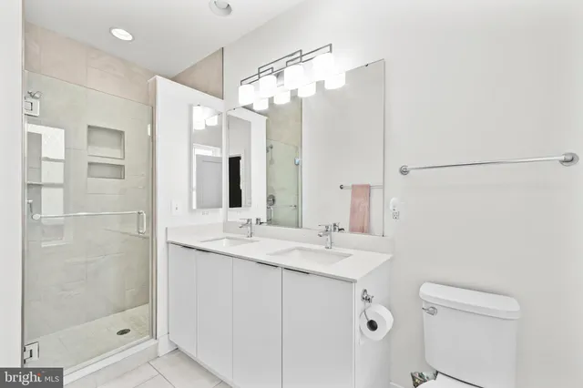a bathroom with a double vanity sink mirror and shower