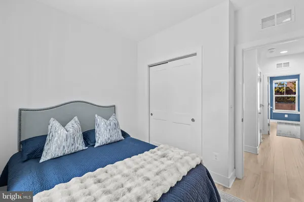 a bedroom with bed and hardwood floor