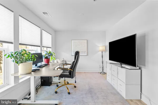 a view of a workspace with furniture and a flat screen tv