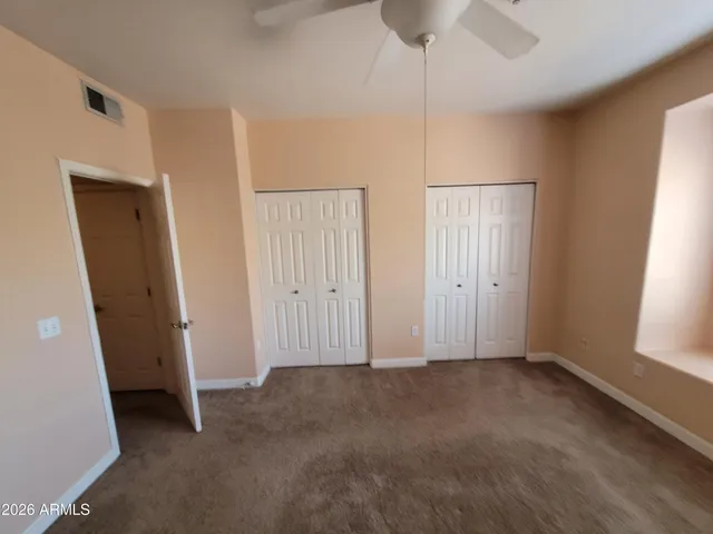 an empty room with windows and closet