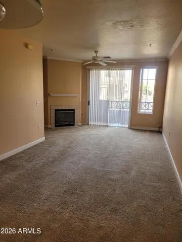 a view of an empty room with a fireplace and a window