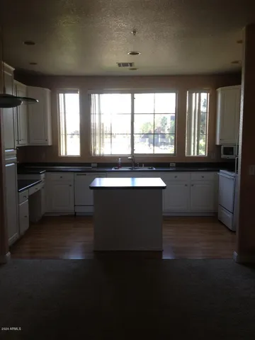 a large kitchen with granite countertop a stove top oven a sink and dishwasher
