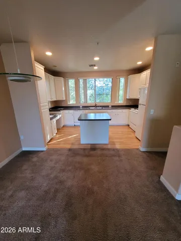 a view of large kitchen with a sink and a refrigerator