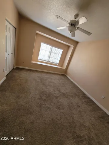 an empty room with windows and fan