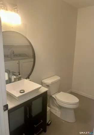 a bathroom with a toilet a sink and mirror