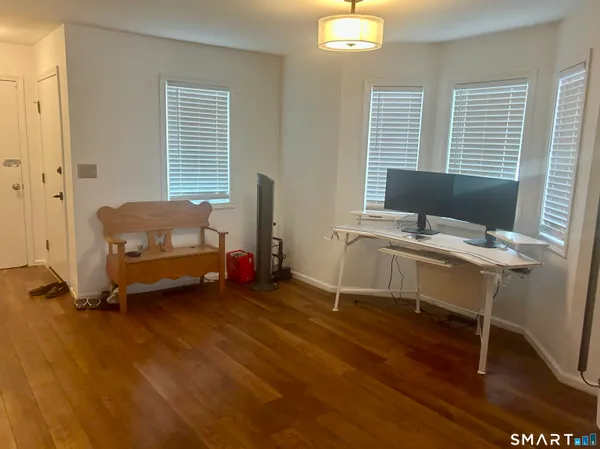 a view of a workspace with furniture and a window
