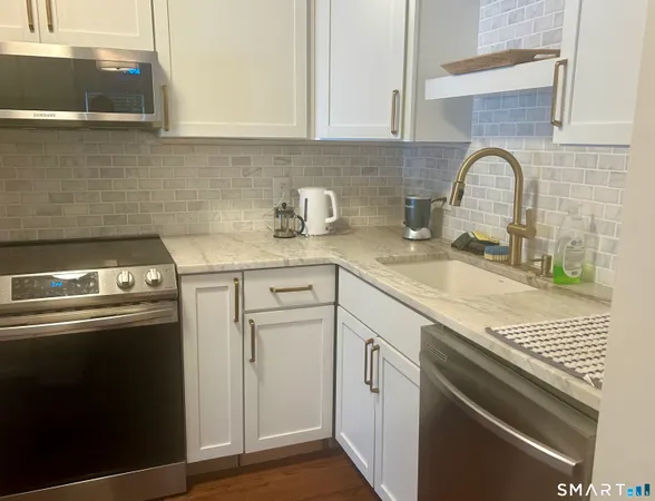 a kitchen with stainless steel appliances granite countertop a sink stove and cabinets