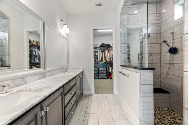 a bathroom with a granite countertop sink a toilet and shower