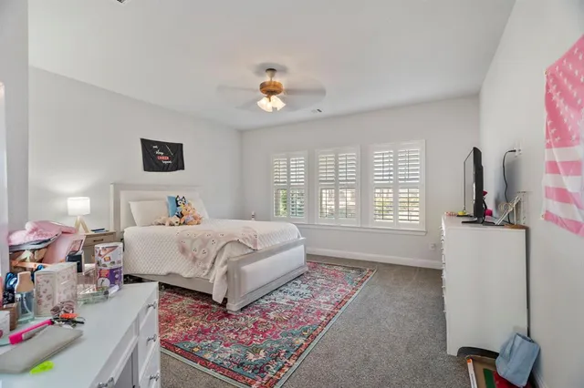 a bedroom with a bed a chandelier and a window