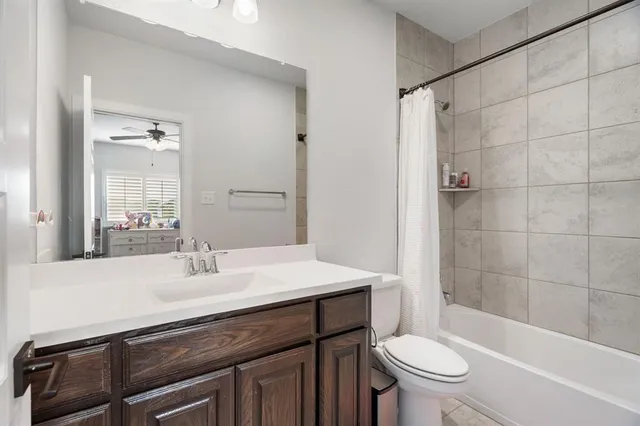 a bathroom with a sink a toilet a mirror and shower