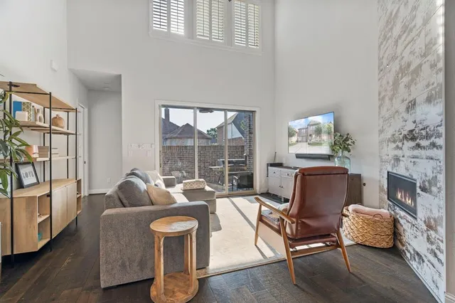 a living room with furniture a fireplace and a floor to ceiling window