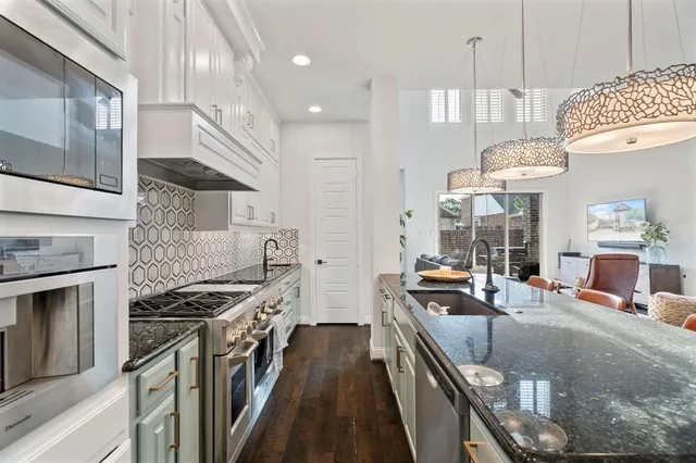 a kitchen with stainless steel appliances granite countertop a stove a sink and a refrigerator