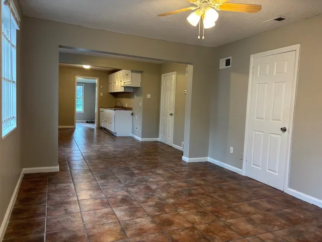 a view of a hallway to a livingroom with furniture