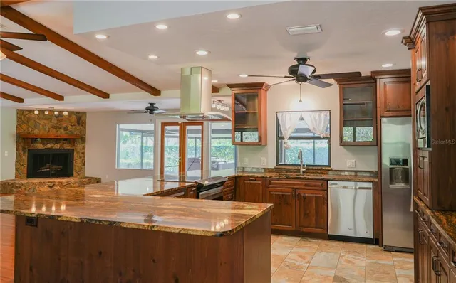 a kitchen with stainless steel appliances granite countertop a sink and a refrigerator