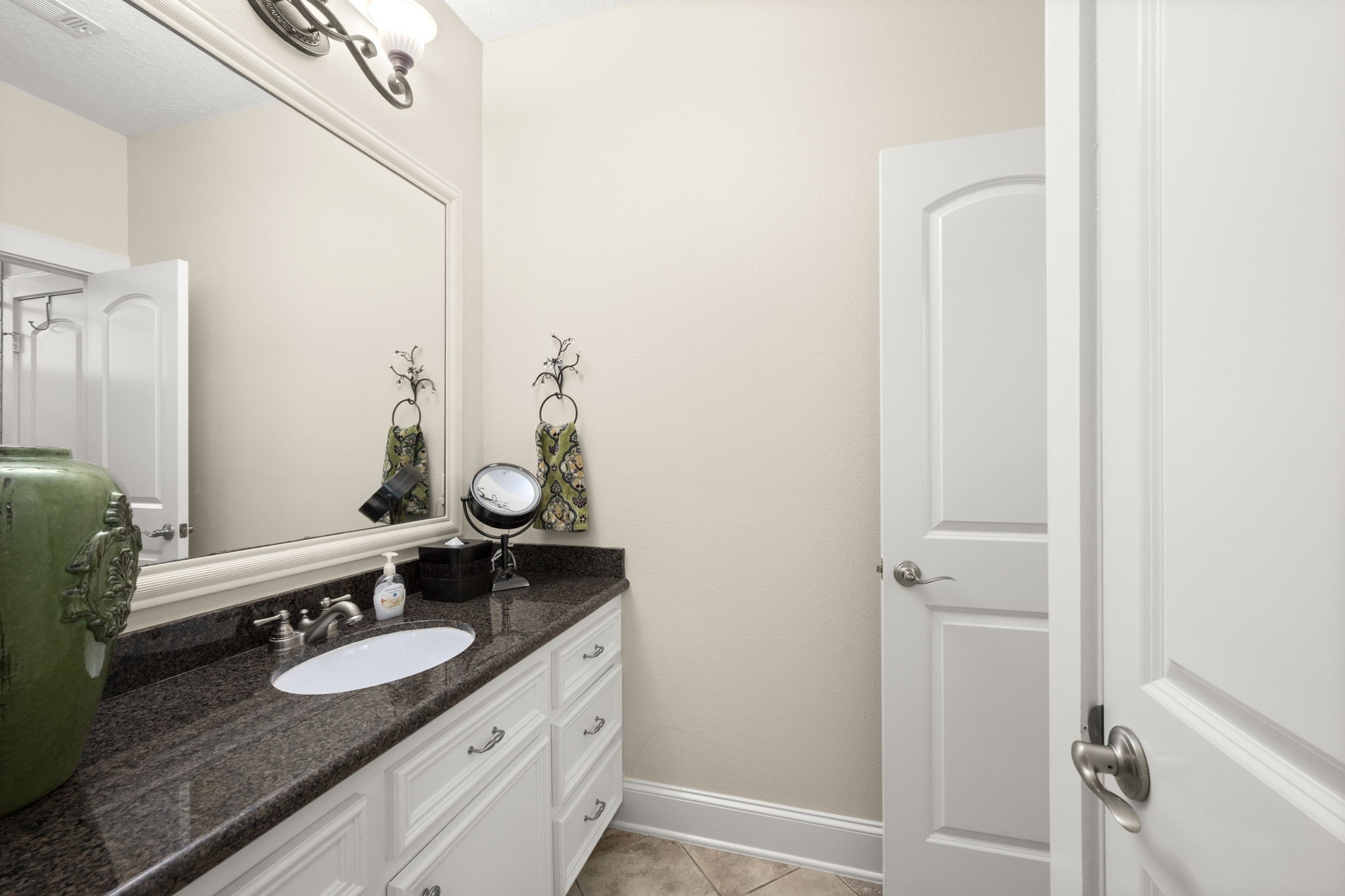 4106 Angling Lane Spring, TX 77386 - Photo 44 of 50 Elegant bathroom #3 shared with bedrooms #3 & #4 with a spacious granite countertop, sleek fixtures, and ample cabinet storage, enhanced by a large mirror and stylish lighting.