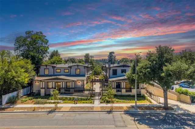front view of house with a yard and large trees