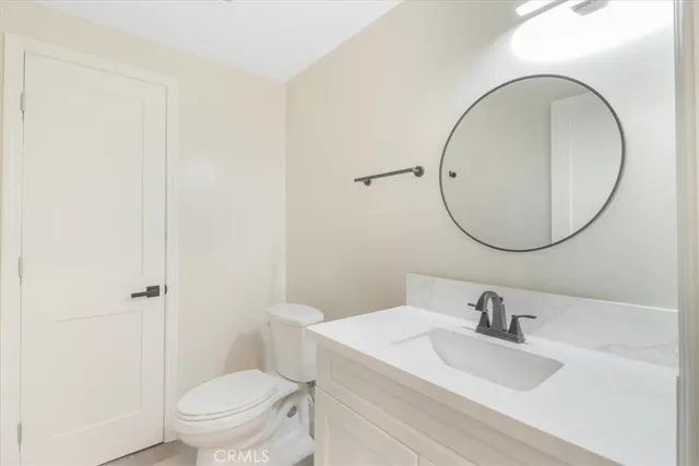 a bathroom with a sink a toilet and a mirror