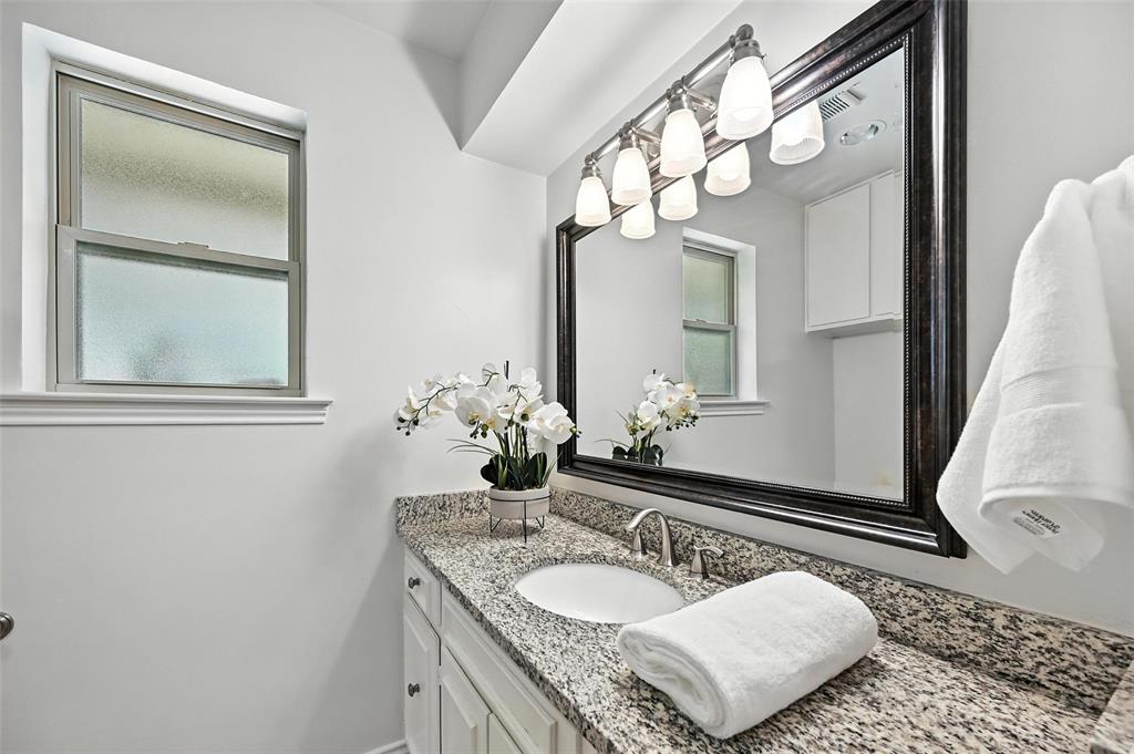 7407 Authon Drive Dallas, TX 75248 - Photo 18 of 31 a bathroom with a granite countertop sink and a mirror