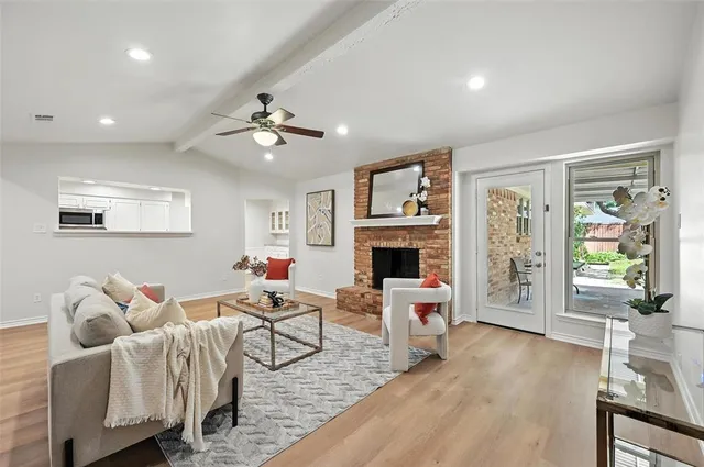 a living room with furniture a fireplace and a table with wooden floor