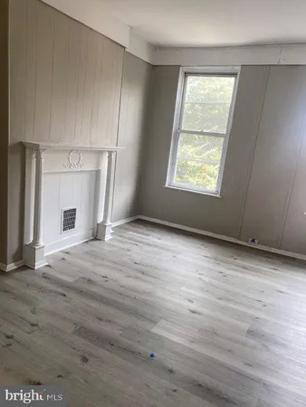 an empty room with windows and fireplace