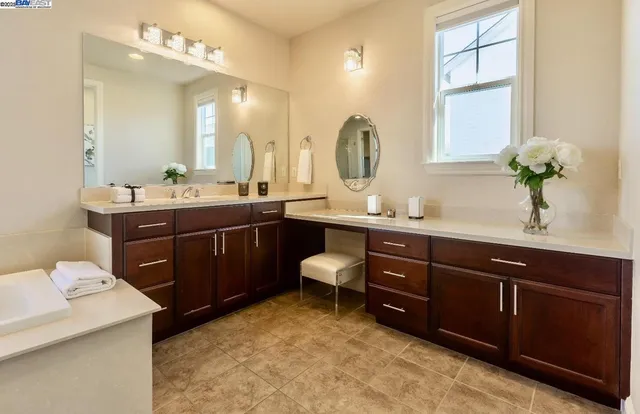 a spacious bathroom with a bathtub sink and mirror