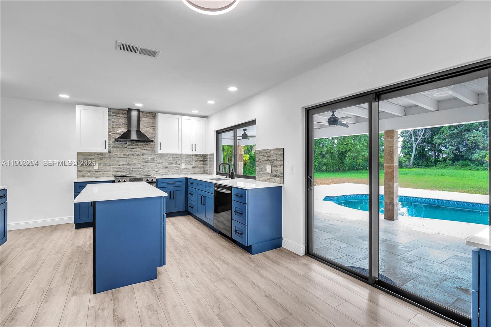 11476 Sundance Lane Boca Raton, FL 33428 - Photo 12 of 45 a large kitchen with kitchen island a large counter top and stainless steel appliances