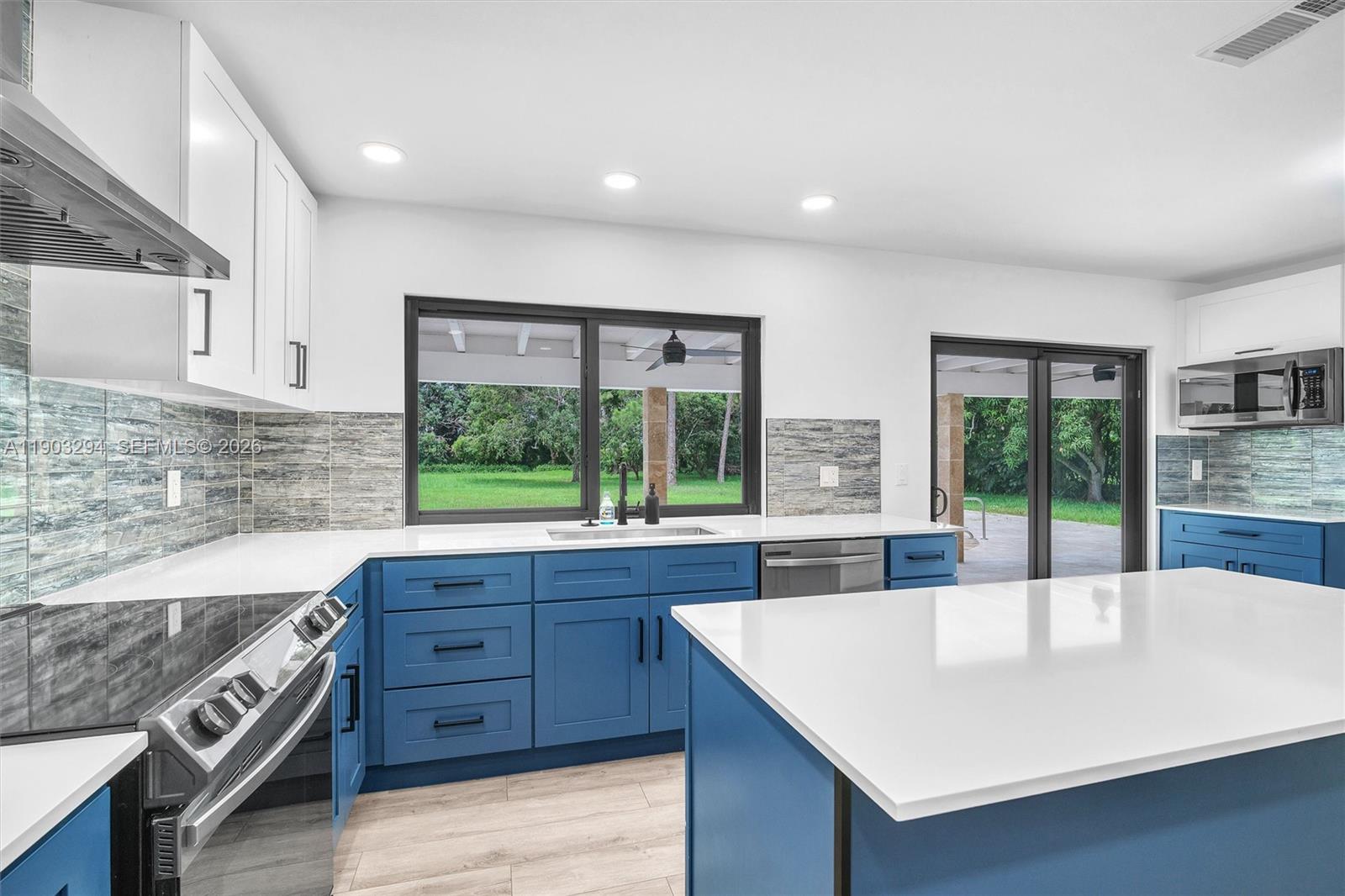 11476 Sundance Lane Boca Raton, FL 33428 - Photo 18 of 45 a large kitchen with kitchen island a large window in it