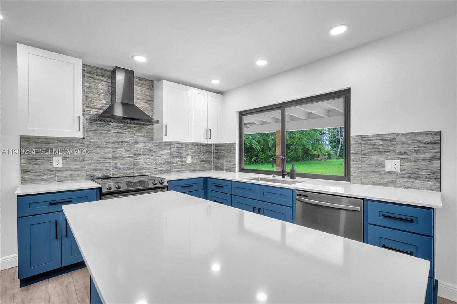 11476 Sundance Lane Boca Raton, FL 33428 - Photo 19 of 45 a kitchen with stainless steel appliances a sink stove and cabinets