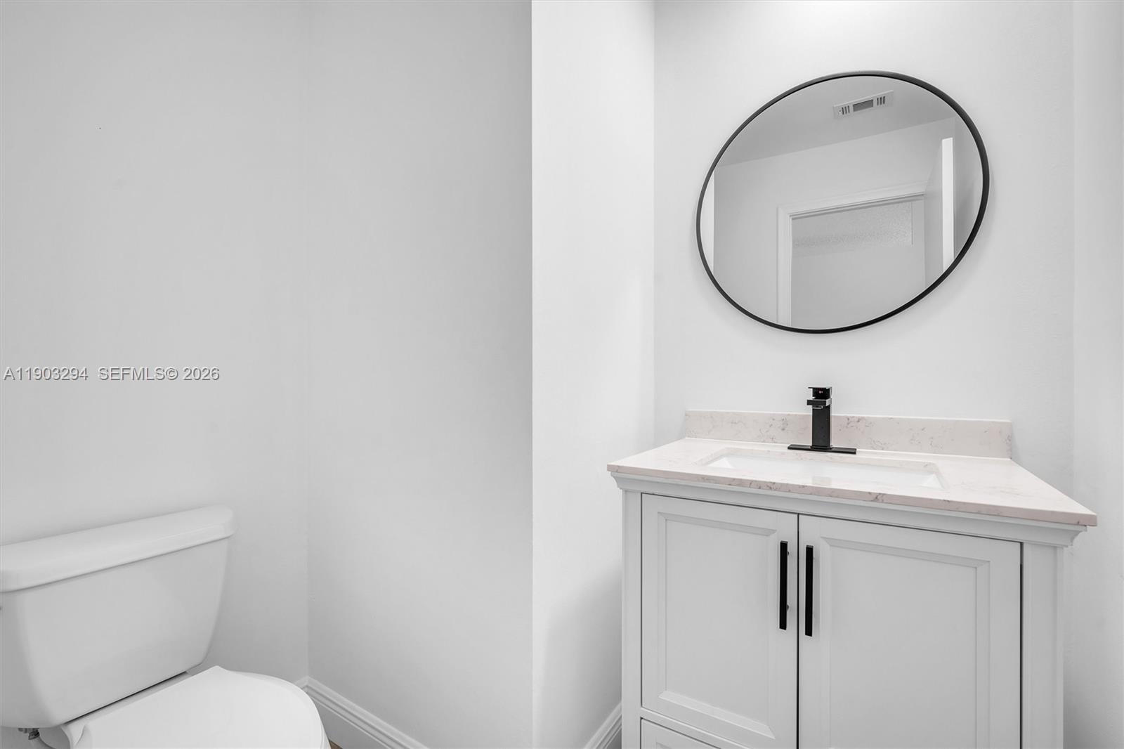 11476 Sundance Lane Boca Raton, FL 33428 - Photo 23 of 45 a bathroom with a toilet a sink and a mirror