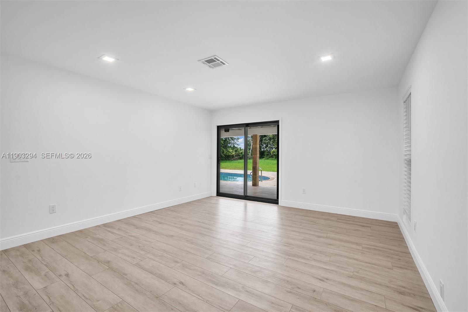 11476 Sundance Lane Boca Raton, FL 33428 - Photo 25 of 45 a view of an empty room with wooden floor and a window