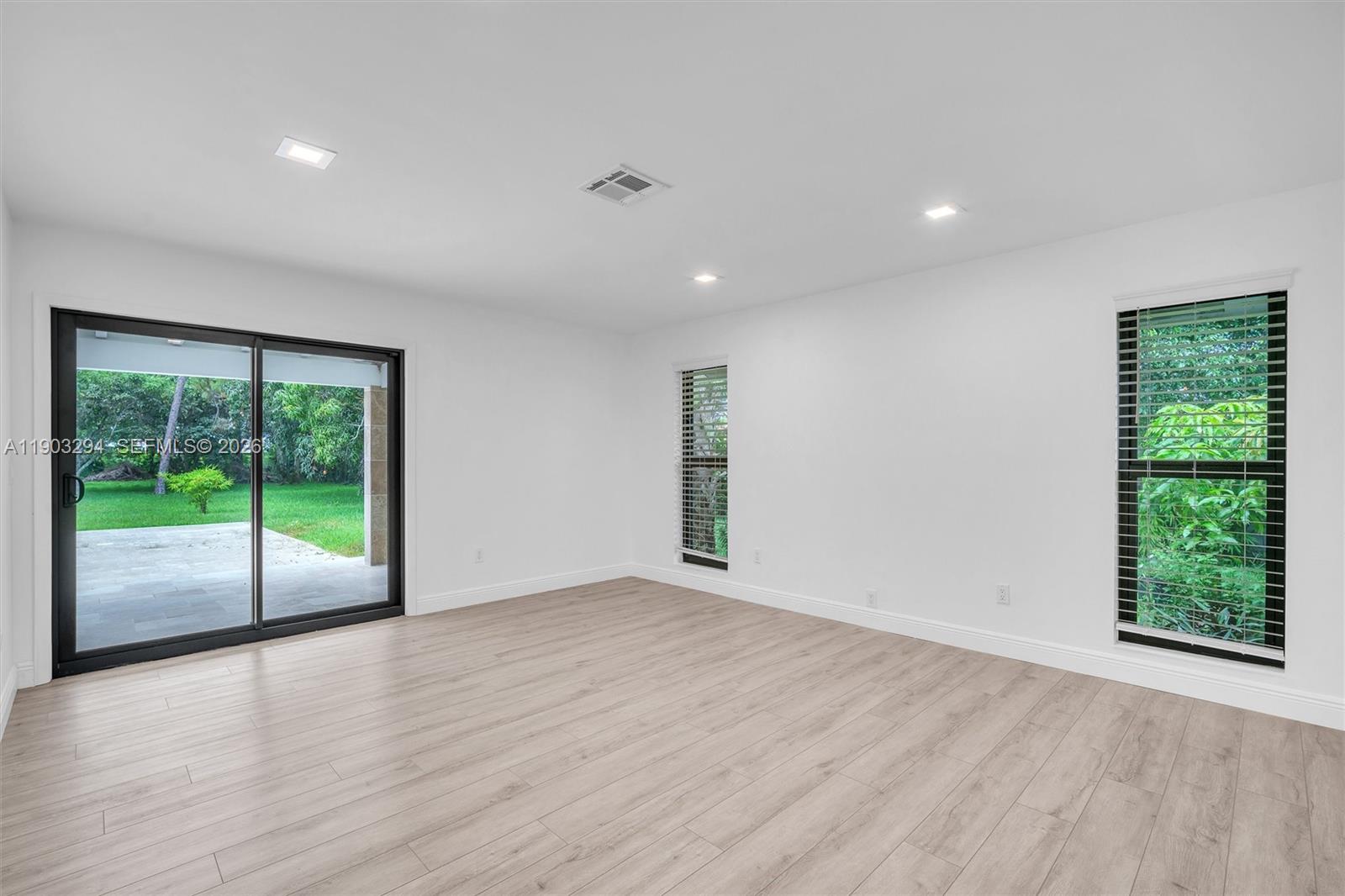 11476 Sundance Lane Boca Raton, FL 33428 - Photo 27 of 45 a view of an empty room with wooden floor and sliding glass door