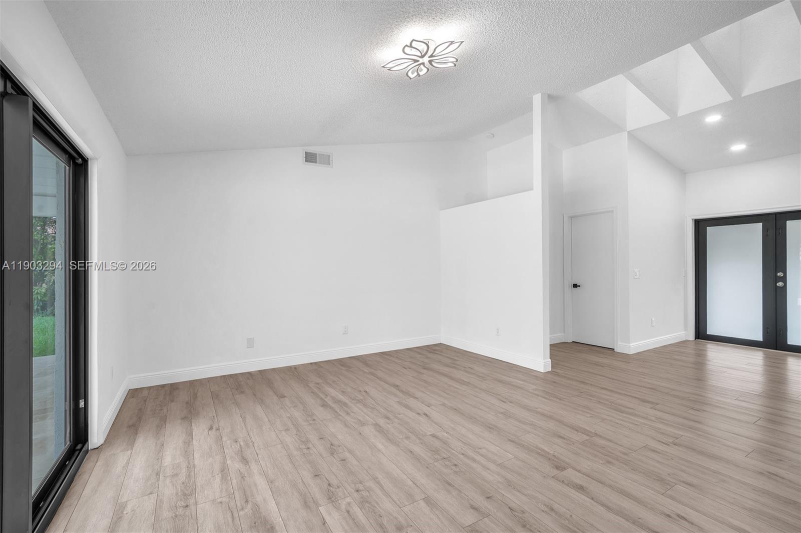 11476 Sundance Lane Boca Raton, FL 33428 - Photo 33 of 45 an empty room with wooden floor and windows