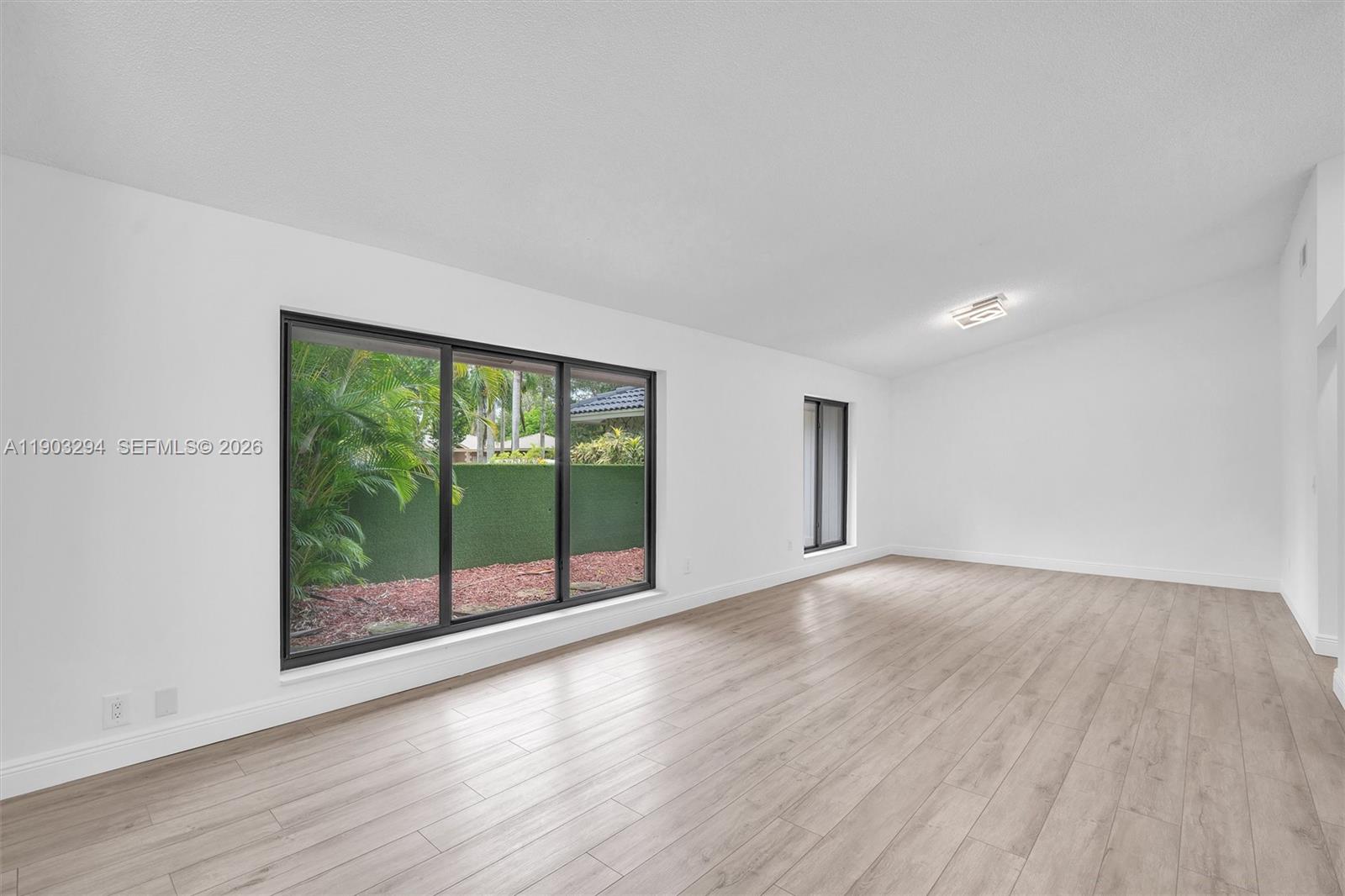 11476 Sundance Lane Boca Raton, FL 33428 - Photo 35 of 45 a view of an empty room with wooden floor and a window