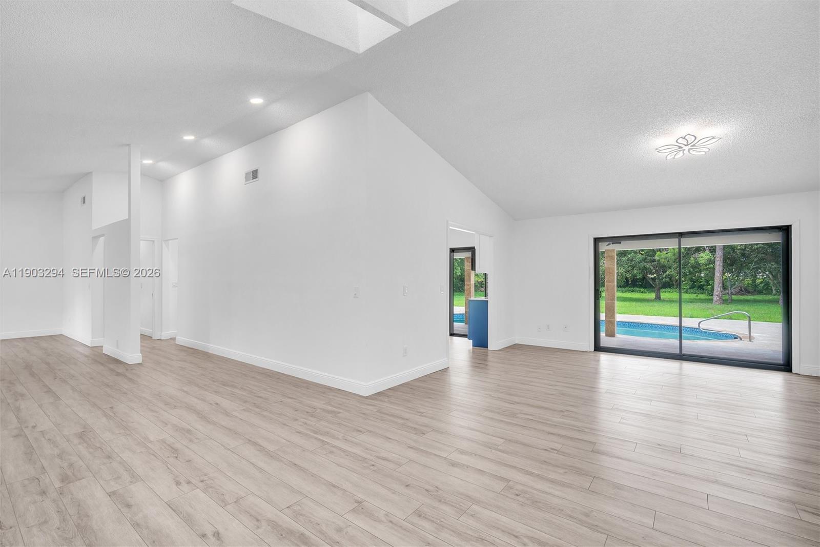 11476 Sundance Lane Boca Raton, FL 33428 - Photo 7 of 45 a view of an empty room with wooden floor and a window