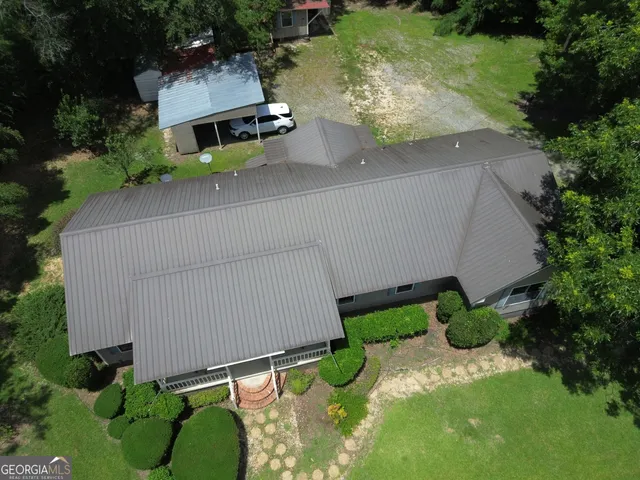 a aerial view of a house with pool and a yard