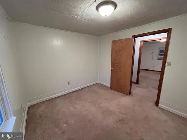 an empty room with closet and mirror
