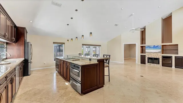 a kitchen with stainless steel appliances granite countertop a sink stove and cabinets