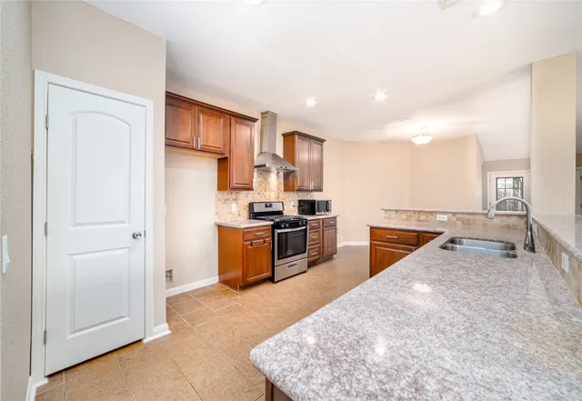 a kitchen with stainless steel appliances granite countertop a stove a sink and a refrigerator