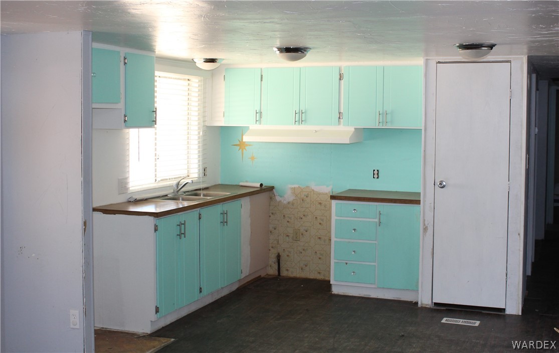 3635 Bowie Road Golden Valley, AZ 86413 - Photo 8 of 15 a room with cabinets and a refrigerator