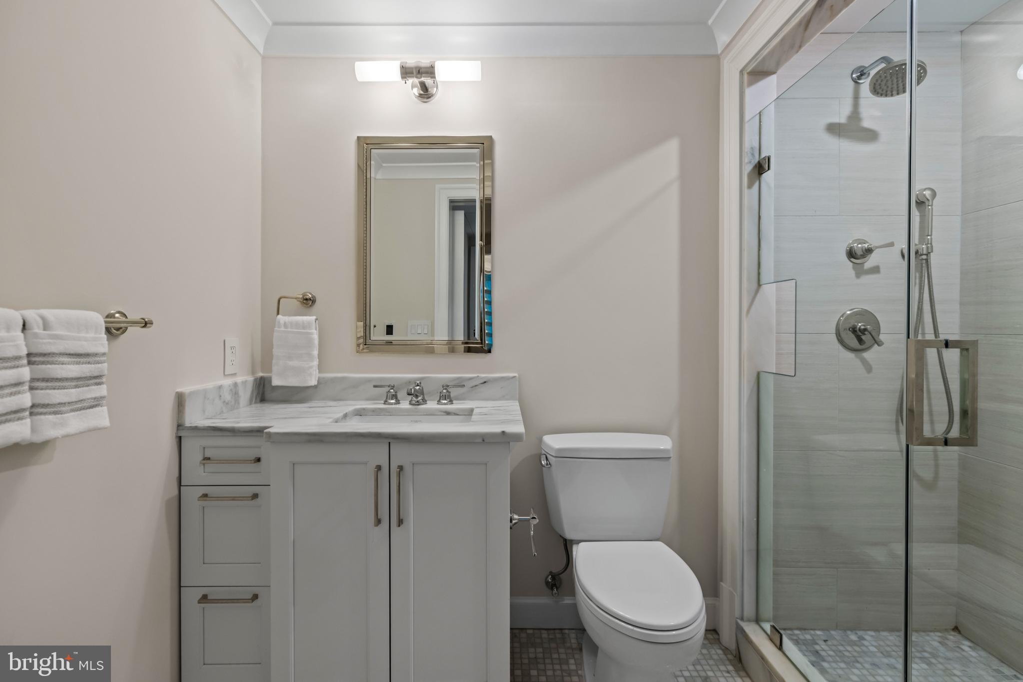 1108 16th Street Northwest, Unit 504 Washington, DC 20036 - Photo 13 of 22 a bathroom with a granite countertop toilet a sink a mirror a shower and vanity