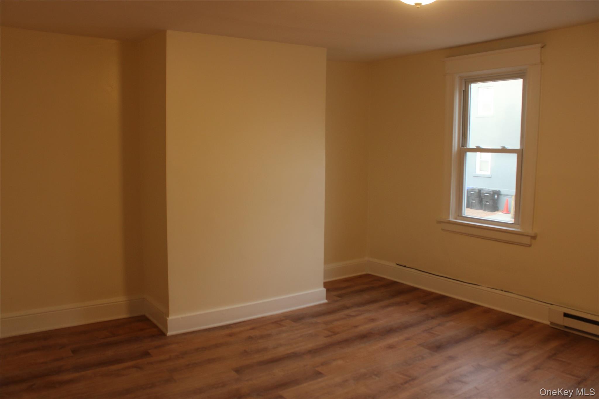 52 South Bridge Street, Unit 1 Poughkeepsie, NY 12601 - Photo 6 of 27 an empty room with wooden floor and windows