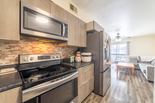 a kitchen with granite countertop wooden cabinets and stainless steel appliances