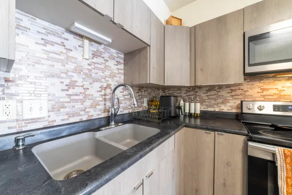 a kitchen with granite countertop a sink a stove and cabinets