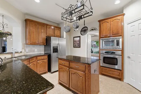 a kitchen with stainless steel appliances granite countertop a refrigerator and microwave