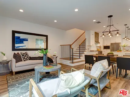 a kitchen with stainless steel appliances kitchen island granite countertop a table chairs and a refrigerator