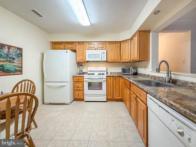 a kitchen with stainless steel appliances granite countertop a stove sink and cabinets