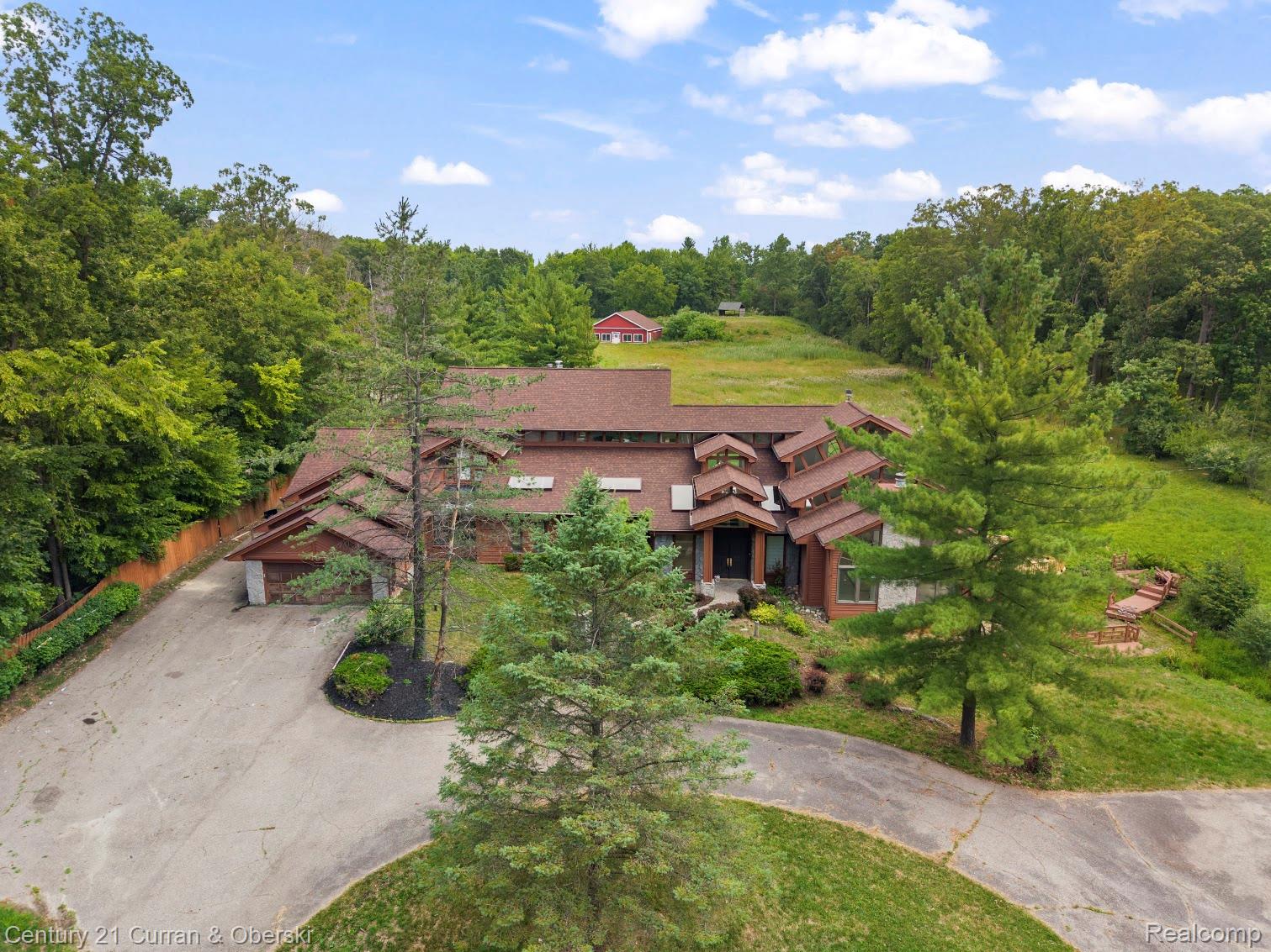 Architecturally distinct property with a multi-level roofline, surrounded by mature trees