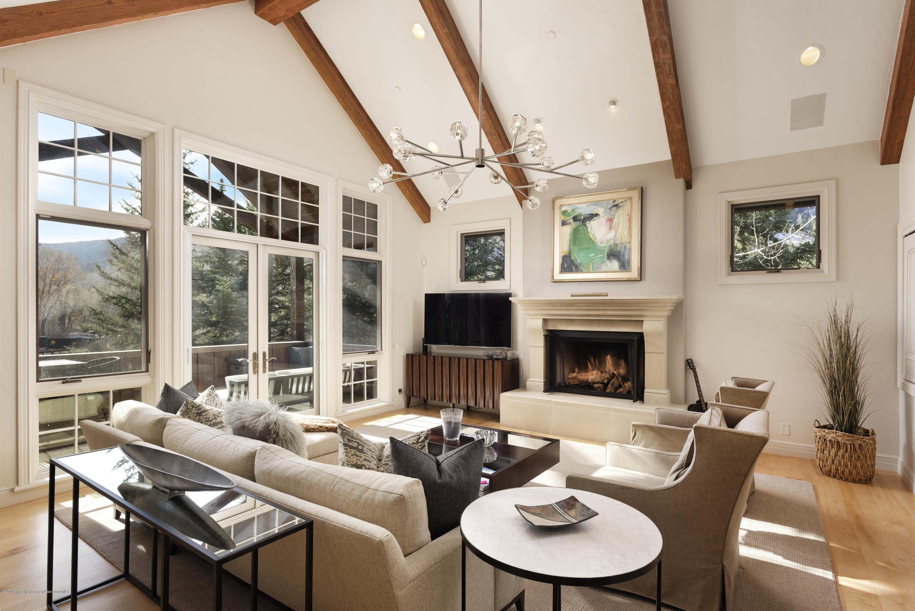 a living room with furniture a large window and a fireplace