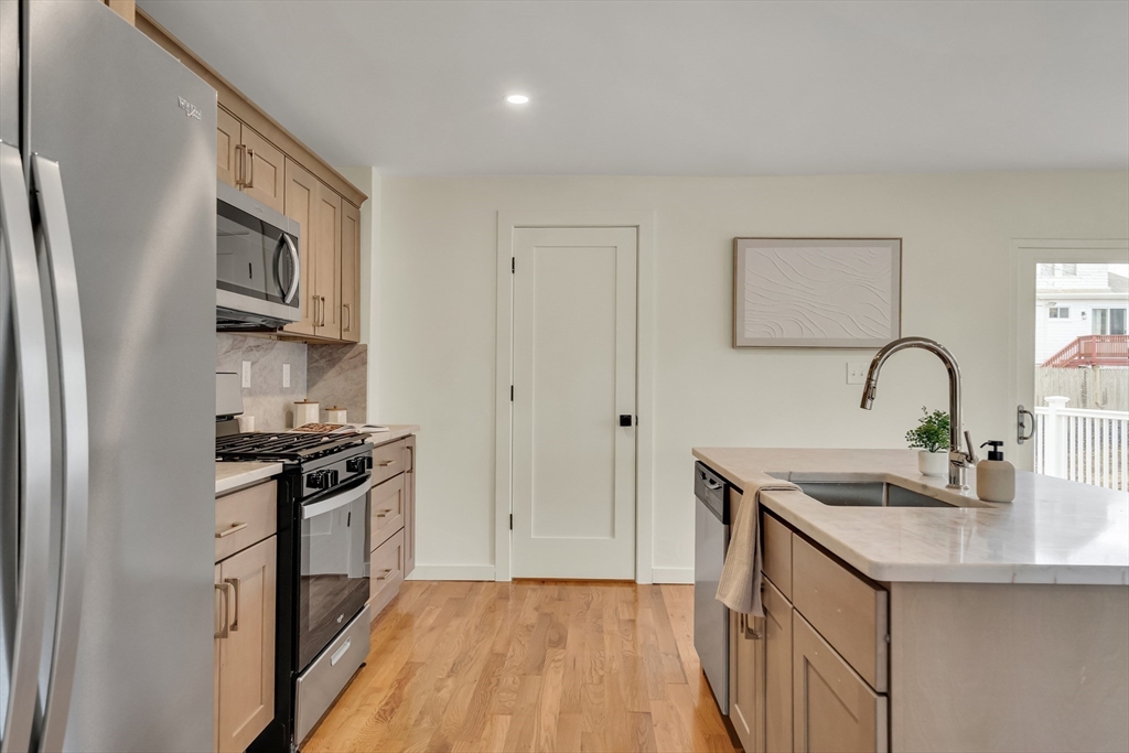 56 Riverview Street Dedham, MA 02026 - Photo 9 of 29 a kitchen with stainless steel appliances granite countertop a sink stove and refrigerator