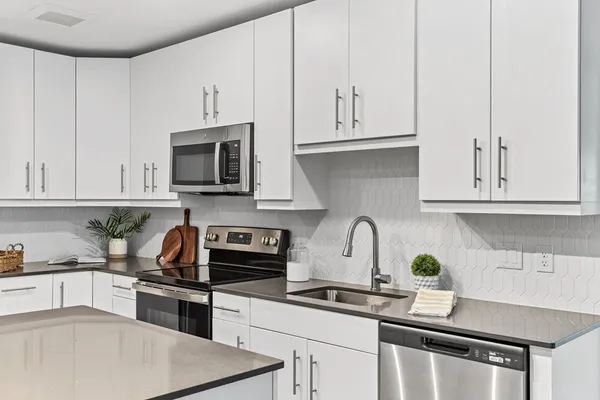 a kitchen with granite countertop white cabinets and stainless steel appliances